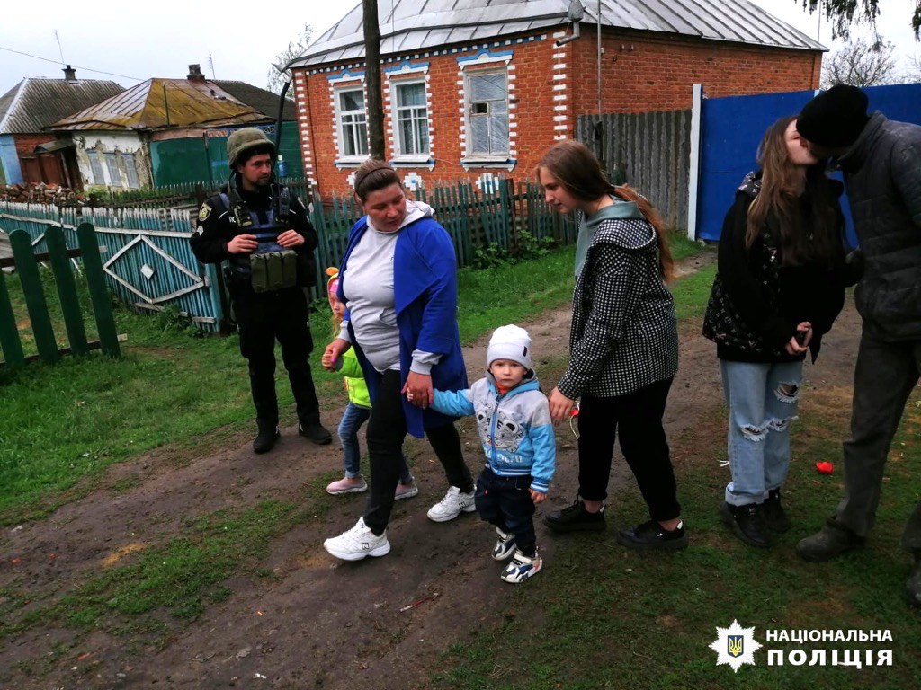A Ukrainian family with young children being escorted out of a frontline village in Kharkiv Oblast by police.